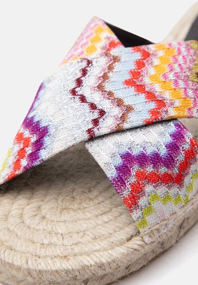 Sandale à bout ouvert avec semelle en jute tissé et brides en maille zigzag multicolores dans des nuances de blanc, rouge, violet, jaune et bleu.
