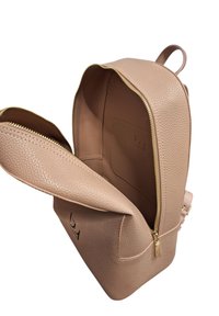 Zaino in pelle beige texture con zip dorata, dotato di un ampio interno e una tasca con un logo in rilievo discreto.