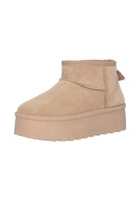 Botines de ante con plataforma en tono beige, punta redonda, puño elástico y un tirador en la parte trasera. Suela de goma texturizada para mayor agarre.