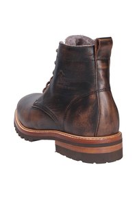 Bottine en cuir marron avec orteil arrondi, fermeture à lacets, doublure douce et semelle texturée durable. Présente un détail de logo en relief.