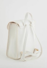 Sac à dos en cuir blanc avec une surface texturée, des coutures légères et des bretelles réglables. Il dispose d'une fermeture à rabat et d'un design épuré.