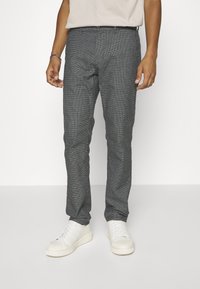 Gray textured trousers with a subtle pattern, featuring a straight fit and front pockets, paired with white sneakers.