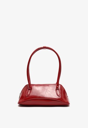 Kleine glanzende rode leren handtas met twee afgeronde handvatten en een ritssluiting op een witte achtergrond.