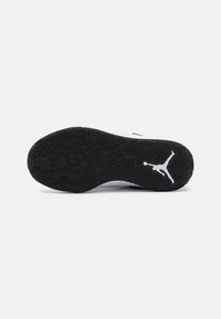 Crna guma s potplatom u ribljoj uzorku, s bijelim Jumpman logom. Dizajn je elegantan s glatkom teksturom.