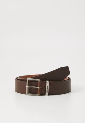 Ceinture en cuir brun avec une boucle rectangulaire en argent et une étiquette de marque. Présente une texture lisse et une extrémité effilée pour le réglage.