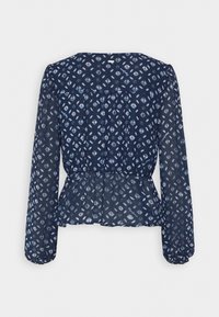 Blouse transparente bleu marine avec imprimé géométrique blanc, manches longues bouffantes, poignets élastiques, taille froncée et empiècement à l'arrière.