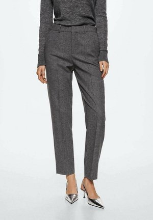 Pantalones ajustados de pattern gris con pierna recta, que cuentan con una cinturilla entallada y una textura sutil, combinados con zapatos de tacón alto plateados.