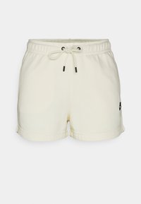 Cream-colored shorts made of soft fabric, featuring an elastic waistband with a drawstring and black accent logo on the hem.