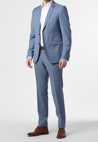 Ljusblå kostym med texturerad tyg, enfärgad kavaj, matchande byxor, vit skjorta, brun läderbälte och skor, rosa slag accenter.