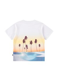Λευκό κοντομάνικο μπλουζάκι με σκηνή παραλίας κατά τη διάρκεια του ηλιοβασιλέματος, με ψηλούς φοίνικες και μια μπλε πισίνα στο προσκήνιο.