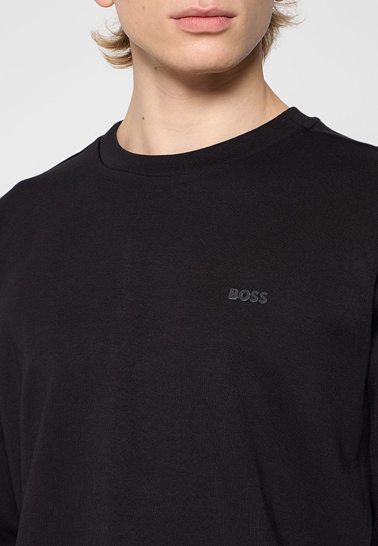 Zwarte langemouwen shirt van katoen, met een ronde hals en subtiele reliëf "BOSS" logo op de linkerborst. Soepele textuur.