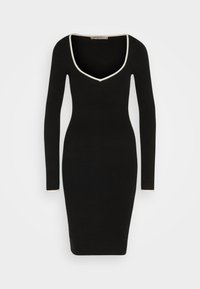 Robe ajustée noire à manches longues avec des finitions blanches autour du décolleté en V profond et des poignets, longueur genoux, silhouette moulante.