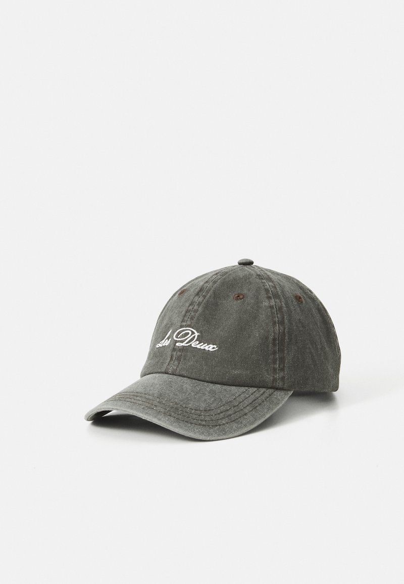 Worn dark gray baseball cap with white "Les Deux" script on front, stitched eyelets, and curved brim on white background.