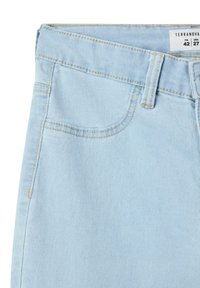 Shorts in denim azzurro chiaro con vestibilità dritta, dotati di cintura in vita, tasche frontali e dettagli di cucitura gialla. Informazioni sull'etichetta visibili.
