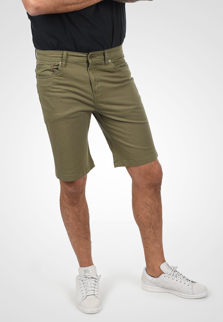 Olivenfarvede shorts med en afslappet pasform, lavet af bomuldsblanding. Har lynlås, fem lommer og diskrete syninger.