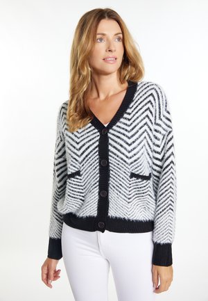 Cardigan lavorato a maglia con un motivo a spina di pesce bianco e nero, caratterizzato da un collo a V, quattro bottoni neri e due tasche frontali.