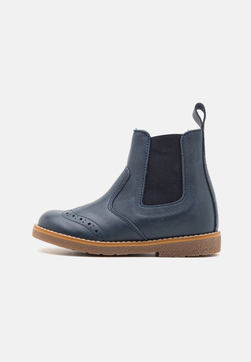 Bottine Chelsea en cuir bleu marine avec des panneaux latéraux élastiques, détails brogue sur le bout, languette arrière et semelle en caoutchouc marron clair.