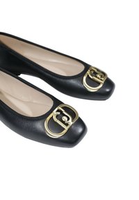 Ballerine in pelle nera con punta quadrata e dettaglio in oro sulla fibbia. Texture liscia, design minimale e fodera interna neutra.