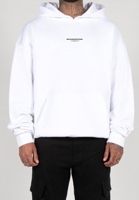 Hvid hoodie lavet af bomuld, med en front kangaroo-lomme og en sort grafisk tekst "METAMORPHOSIS" på brystet. Lange ærmer med ribbede manchetter.