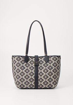Bolso tote con un patrón floral en negro y crema, con acentos y asas de cuero negro. Cierre asegurado con una correa central.