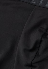 Černá sportovní tkanina s hladkým texturem a mírným leskem. Obsahuje kontrastní pas s embosovaným logem.