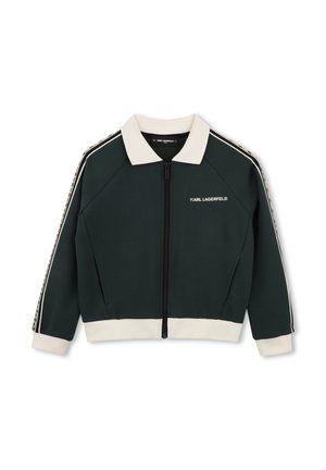 Donkergroene jas met ritssluiting, witte kraag, manchetten en zoom, met witte zijstrepen en de tekst "KARL LAGERFELD" op de borst.