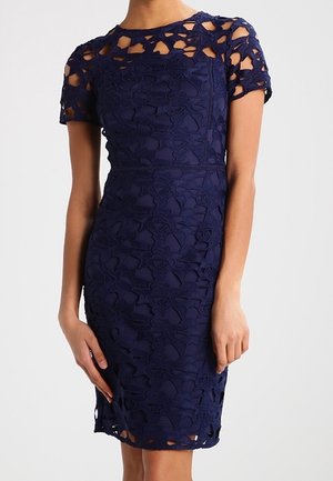 Abito fitted blu navy con sovrapposizione in pizzo decorata con motivi floreali. Maniche corte, scollatura rotonda e finitura testurizzata.