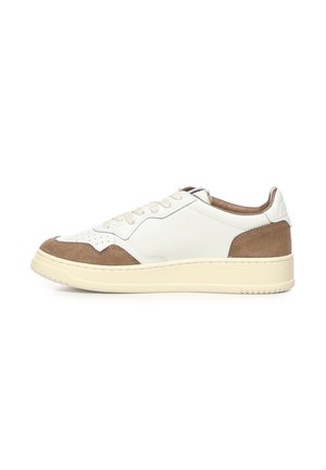 Sneaker bianca low-top con dettagli in camoscio beige sulla punta e sul tallone, suola crema e lacci bianchi mostrata di profilo.