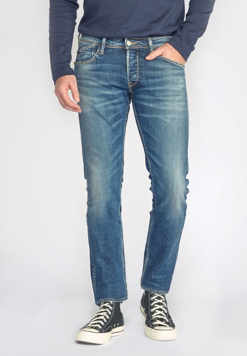 Blauwe denim jeans met een rechte pijpdesign, vervaagde wassing, vijfzakstijl en contrasterende stiksels, gecombineerd met zwarte canvas sneakers.