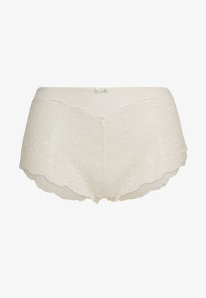 Slip in pizzo beige con bordi scallop, caratterizzato da una texture morbida e un design senza cuciture. Include un piccolo fiocco decorativo in vita.