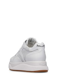 Sneaker bianca caratterizzata da una tomaia in rete e accenti in pelle liscia. Suola bianca spessa con scanalature testurizzate e un piccolo logo nero sul tallone.