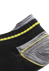 Calzino nero con design testurizzato, dotato di strisce grigie e gialle al polsino e un'area del tallone rinforzata. Materiale a maglia morbida.