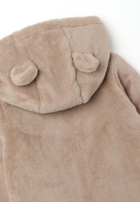 Weicher beiger Fleece-Hoodie mit zwei kleinen runden Plüschohren, die oben an der Kapuze befestigt sind.
