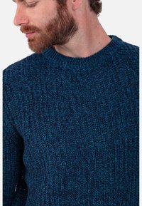 Strickpullover in dunklen Blautönen mit strukturiertem Muster, Rundhalsausschnitt und gerippten Bündchen, gefertigt aus einer weichen Wollmischung.