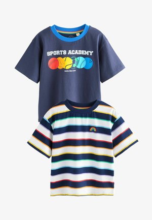 Due T-shirt: una blu navy con un grafico "Sports Academy" e palloni sportivi colorati; l'altra a righe in vari colori con un dettaglio arcobaleno.