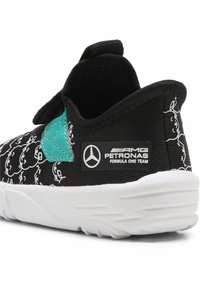 Mustad mustad, millel on valged joonistused, tealde aktsent küljel ja valge kummitald, millel on Mercedes AMG Petronas logo.
