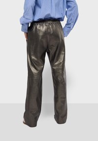 Metalen grijze broek met een relaxte pasvorm. Gemaakt van een glanzend, soepel materiaal. Voorzien van een elastische tailleband voor comfort.