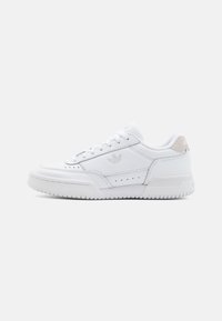 Witte leren sneakers met een suède hielaccent, ronde neus, geperforeerde details en een platte rubberen zool. De veters zijn opvallend op de bovenzijde.