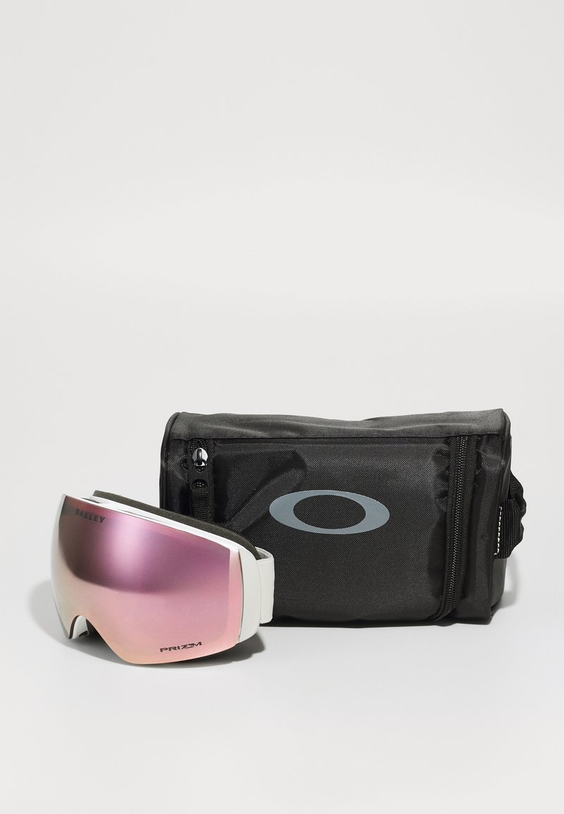 Schneegebinde mit rosa getönten Gläsern, weißem Rahmen und verstellbarem Riemen, begleitet von einem schwarzen Stoffetui mit einem grauen Logo.