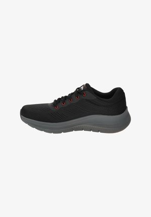 Schwarzer Sportschuh mit Obermaterial aus Mesh, roten Akzenten an den Schnürsenkeln und einer grauen Gummisohle. Leicht gepolstert für Komfort während der Bewegung.
