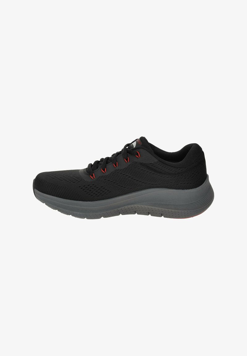Scarpa sportiva nera con tomaia in rete, dettagli rossi sui lacci e suola in gomma grigia. Leggermente imbottita per il comfort durante il movimento.