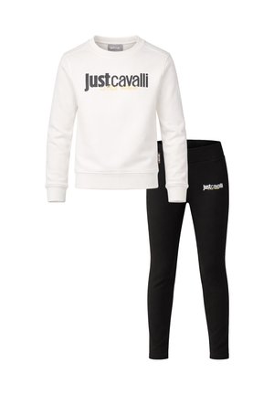 Felpa bianca a maniche lunghe con logo "Just Cavalli" nero abbinata a leggings neri con logo coordinato sull'anca.