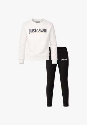 Felpa bianca a maniche lunghe con logo "Just Cavalli" nero abbinata a leggings neri con logo coordinato sull'anca.