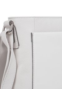 Bežna kožna torbica z teksturirano površino, pravokotne oblike, srebrnimi kovinskimi dodatki in gladkim sprednjim žepom.