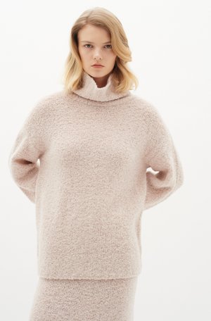 Helles rosa, strukturiertes Sweatshirt mit hohem Kragen und lockerer Passform. Weiches Material mit einer flauschigen Oberfläche, versehen mit herunterhängenden Schultern und langen Ärmeln.
