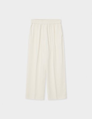 Pantalones anchos de tiro alto de color crema, sueltos, con cintura elástica, mostrados extendidos sobre un fondo claro.