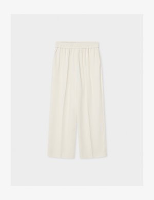 Pantalones anchos de tiro alto de color crema, sueltos, con cintura elástica, mostrados extendidos sobre un fondo claro.