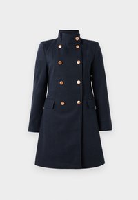Manteau bleu marine à double boutonnage avec un col haut, huit boutons en laiton, manches longues et deux poches à rabat à l'avant, coupe ajustée.