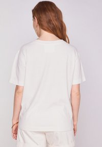 Witte katoenen t-shirt, relaxte pasvorm met korte mouwen, met een klassieke ronde hals en subtiele stiksels bij de schouders.