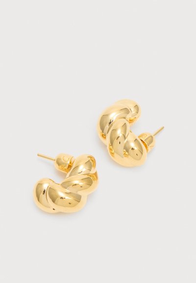 Ζευγάρι λαμπερά χρυσά σκουλαρίκια-κρίκοι με στριφογυριστό σχέδιο σε λευκό φόντο με ορατή ακίδα και υποστήριξη πεταλούδας.